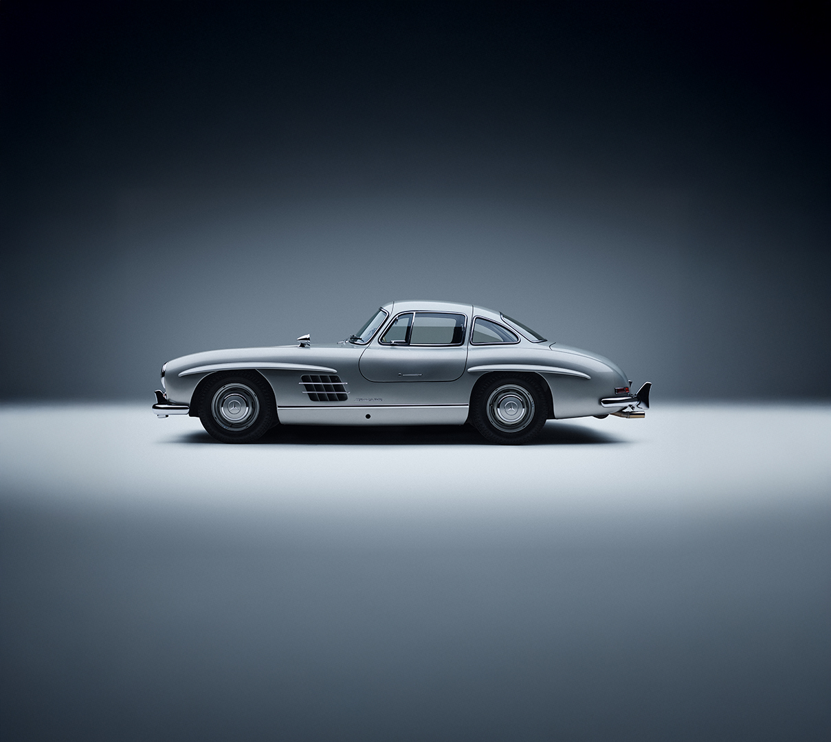 Mercedes-Benz 300 SL El Mercedes-Benz 300 SL de lado con un fondo azul