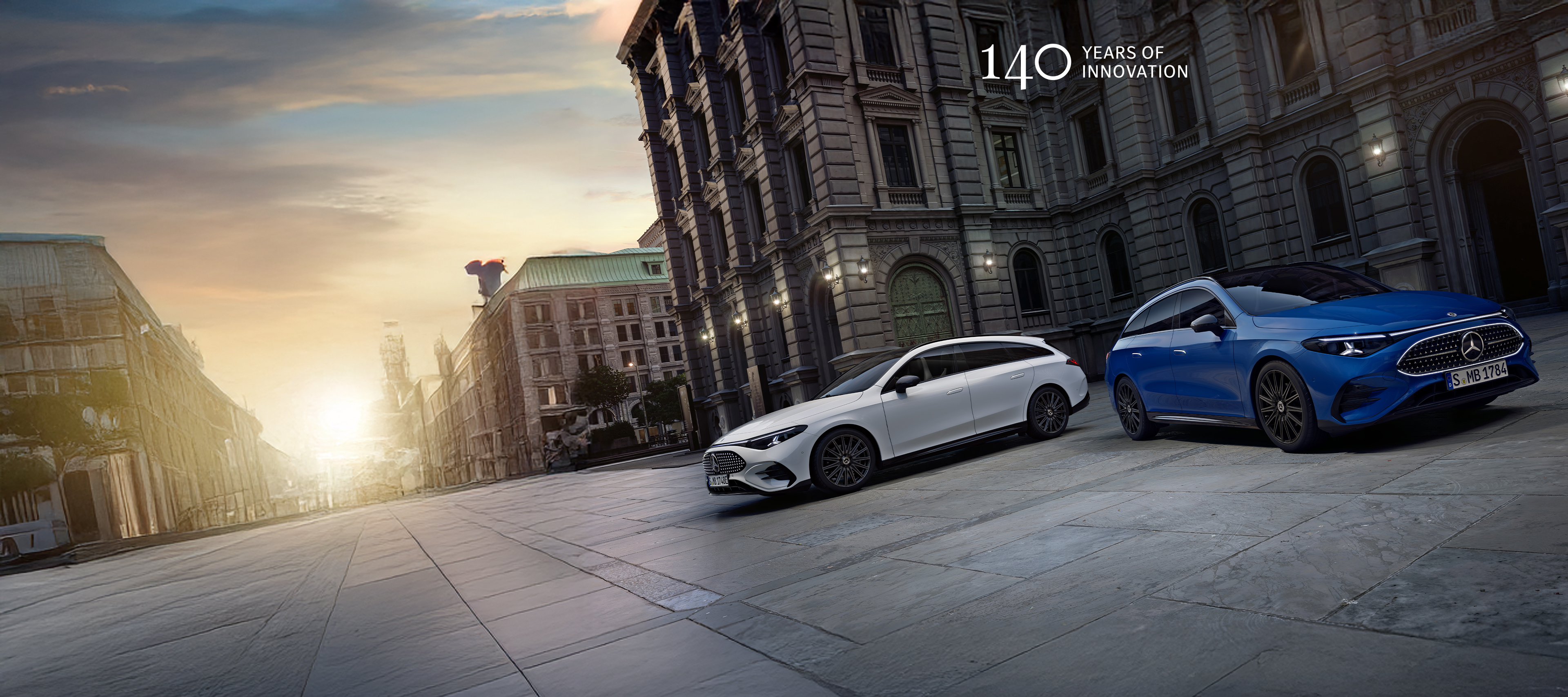 CLA Shooting Brake | Mercedes-Benz Visual del CLA eléctrico en blanco y el CLA híbrido en azul de Mercedes-Benz aparcados frente de un edificio