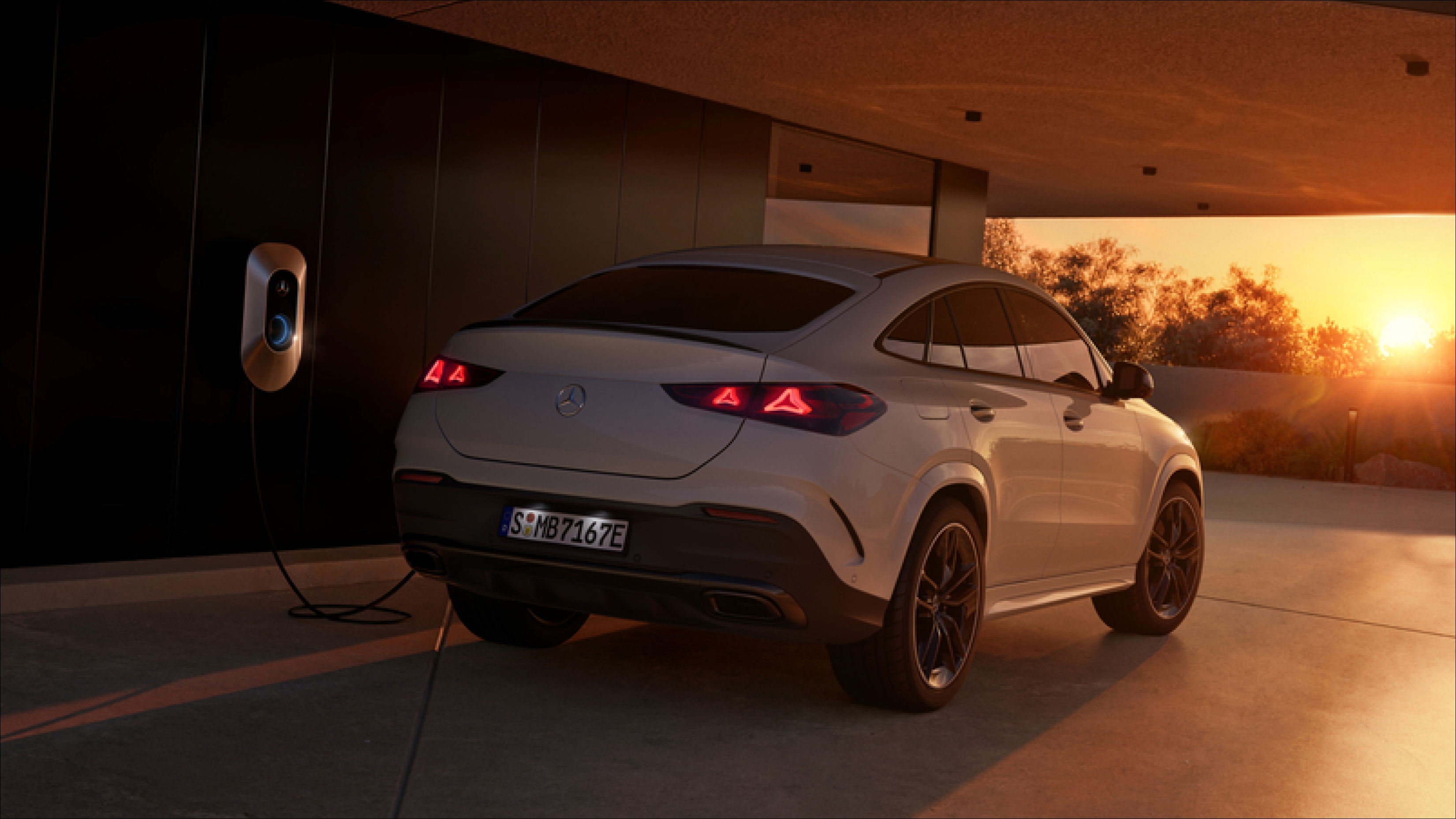 Oferta | GLE Coupé Híbrido Enchufable | Mercedes-Benz visual lateral de un GLE Coupé en color blanci enchufado a un cargador