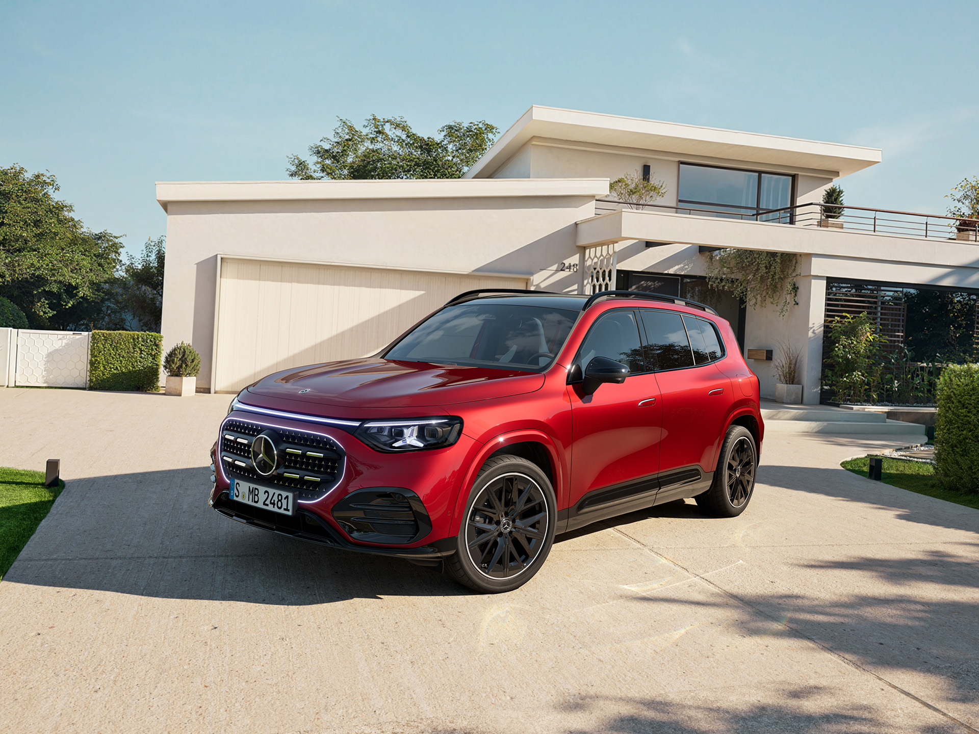 GLB | Mercedes-Benz Visual de un GLB rojo de Mercedes-Benz aparcado fuera una casa