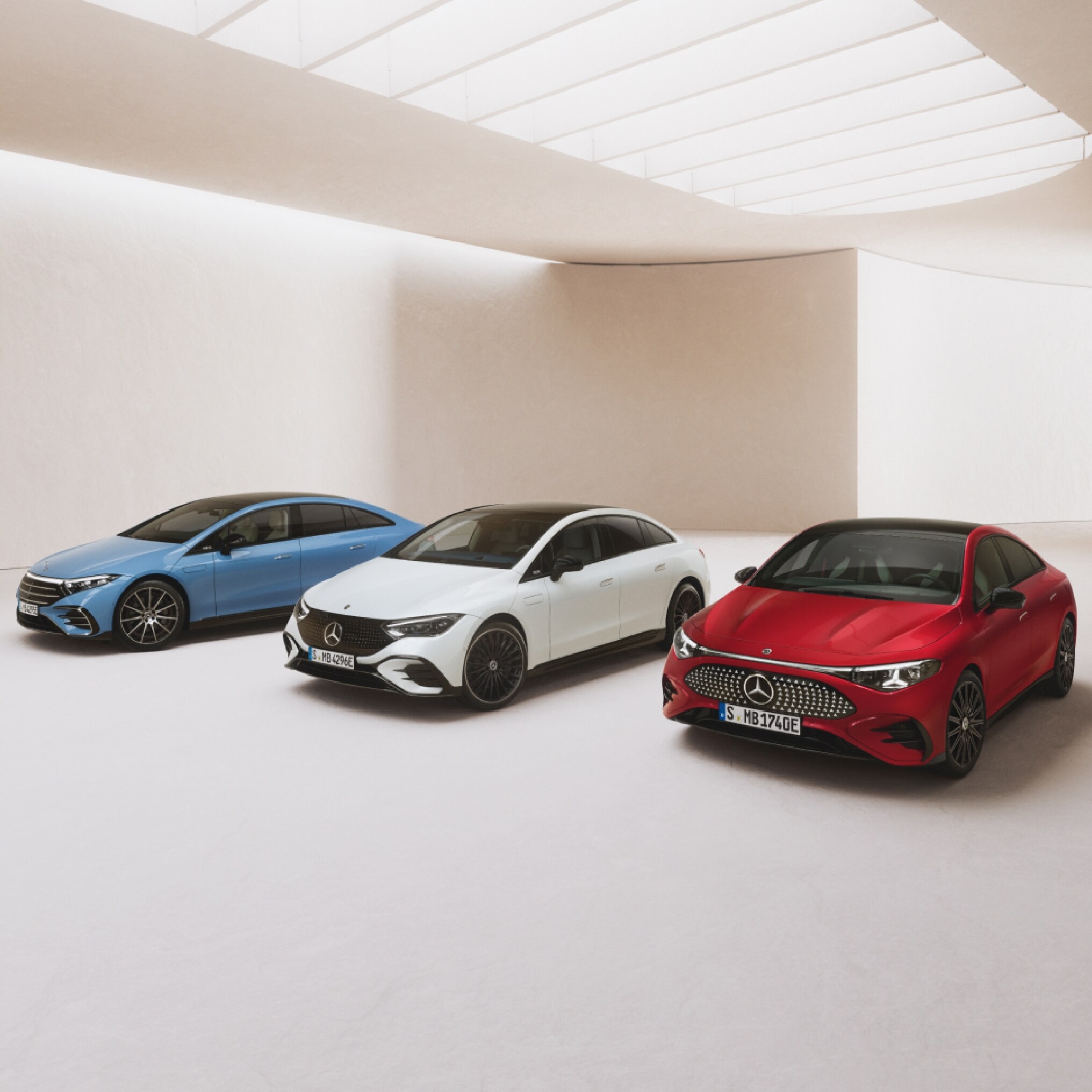 visual lateral de 3 vehículos de Mercedes-Benz en color rojo, blanco y azul