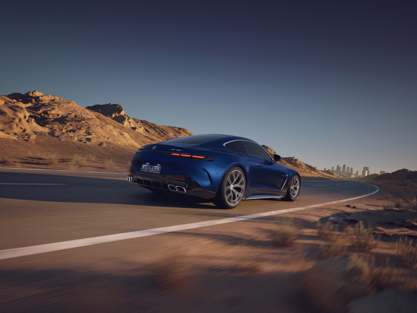 visual trasero de un Mercedes-AMG GT Coupé dos puertas en color azul por la carretera del desierto