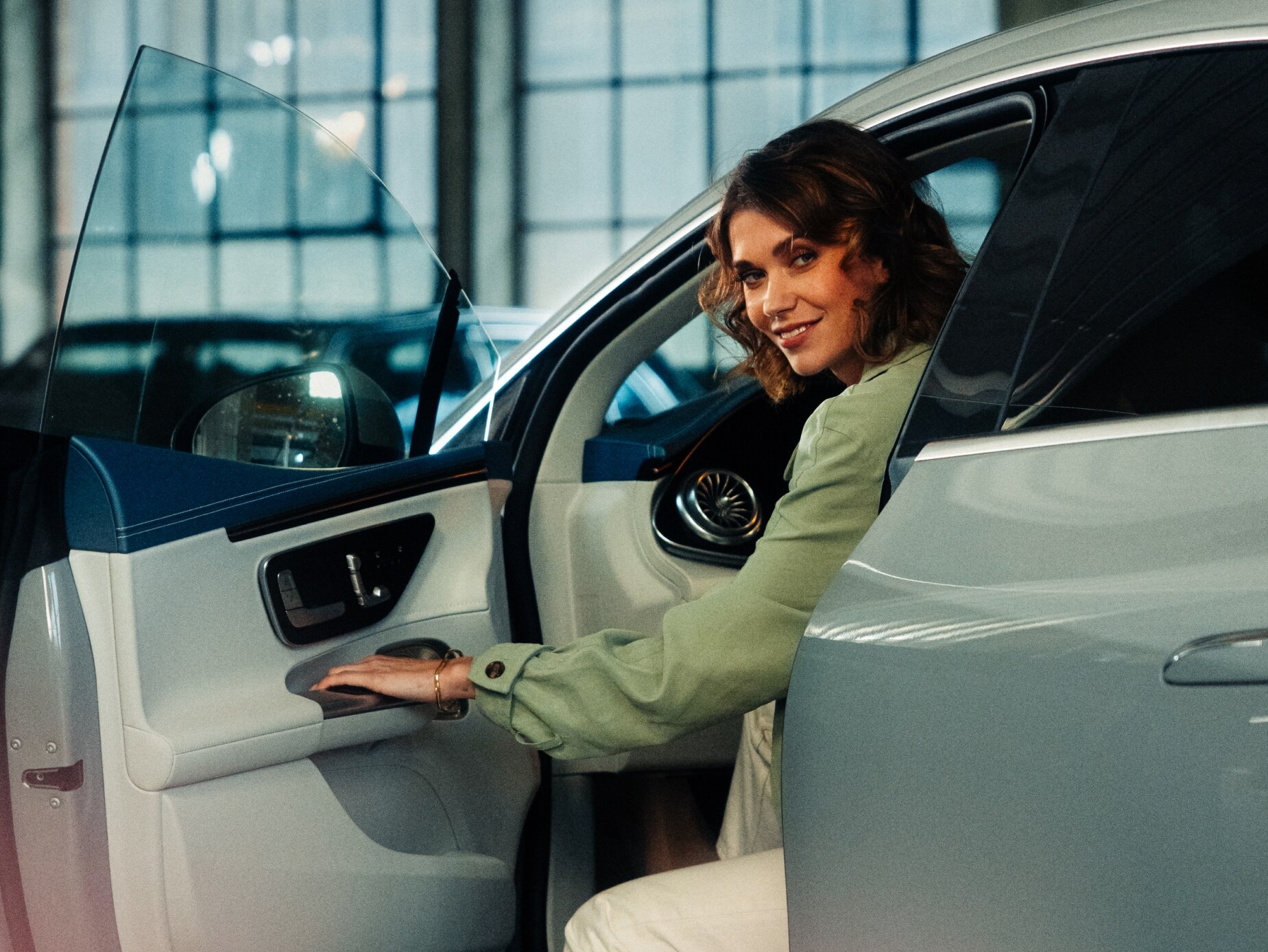 visual de una mujer abriendo la puerta del coche desde el lado del conductor y mirando a la cámara