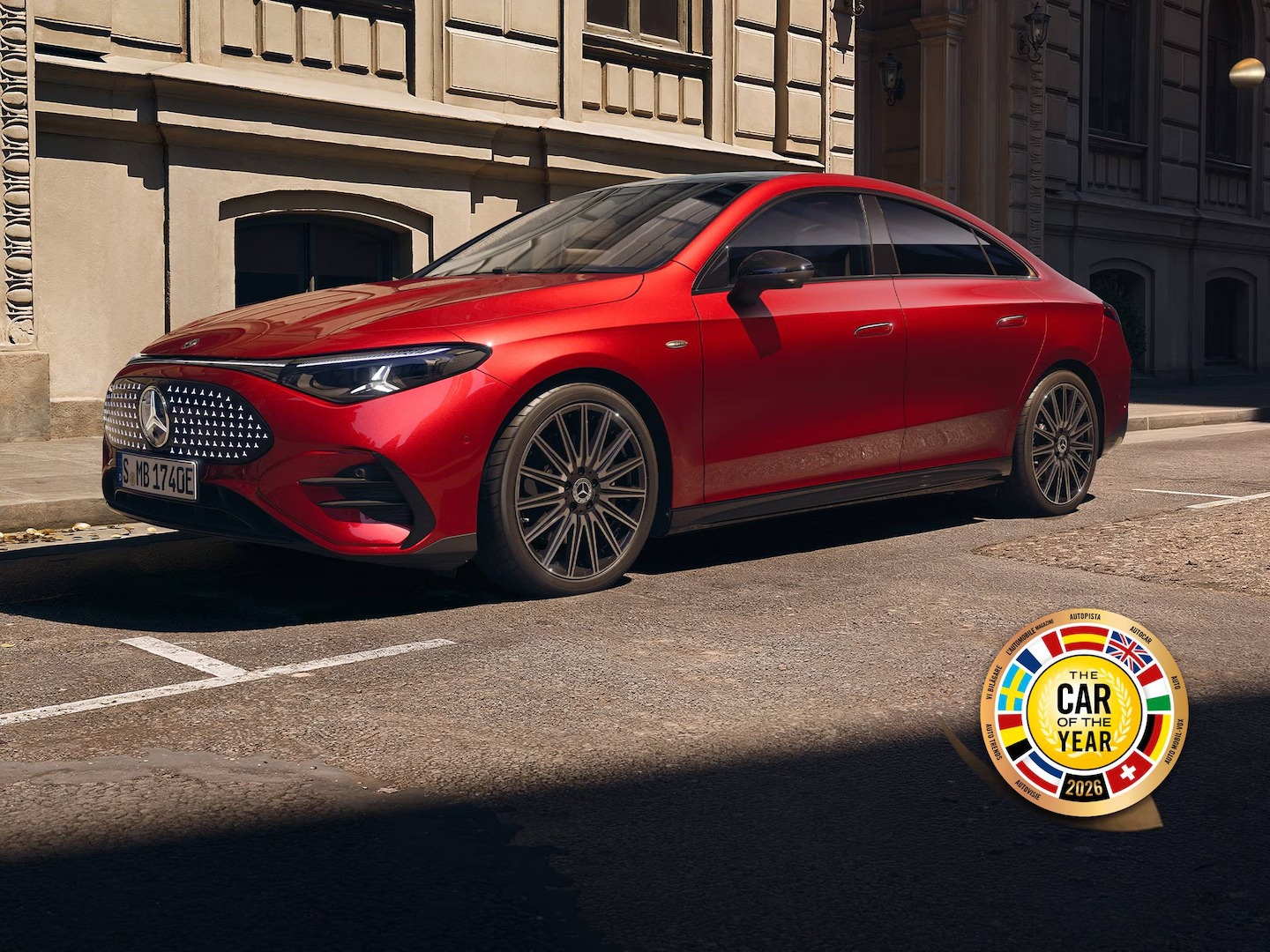 Mercedes-Benz CLA | Mercedes-Benz CLA eléctrico de color rojo con edificios al fondo con el logo del premio Car of the year