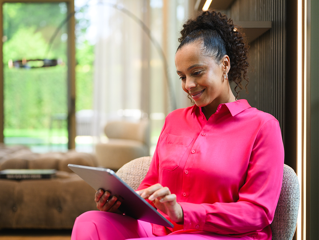 Portal del cliente | Servicios financieros | Mercedes-Benz Una mujer sentada mirando una tablet