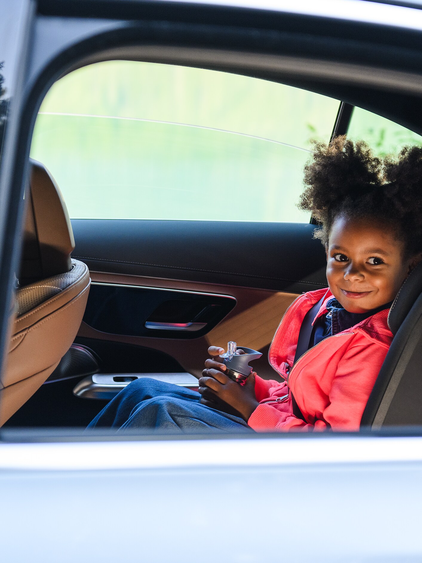 Una niña sentada dentro de un vehículo Mercedes-Benz.
