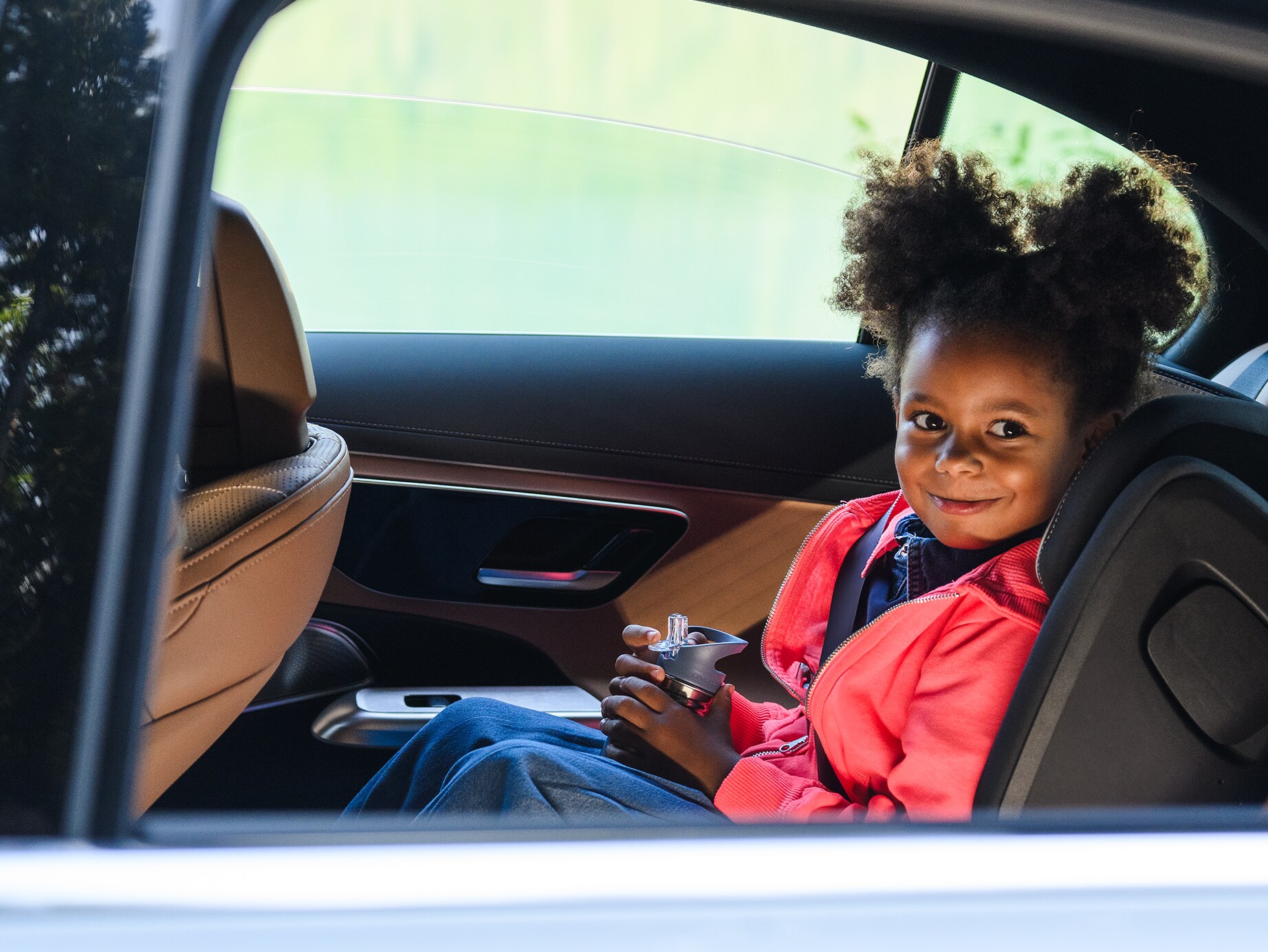 Una niña sentada dentro de un vehículo Mercedes-Benz.