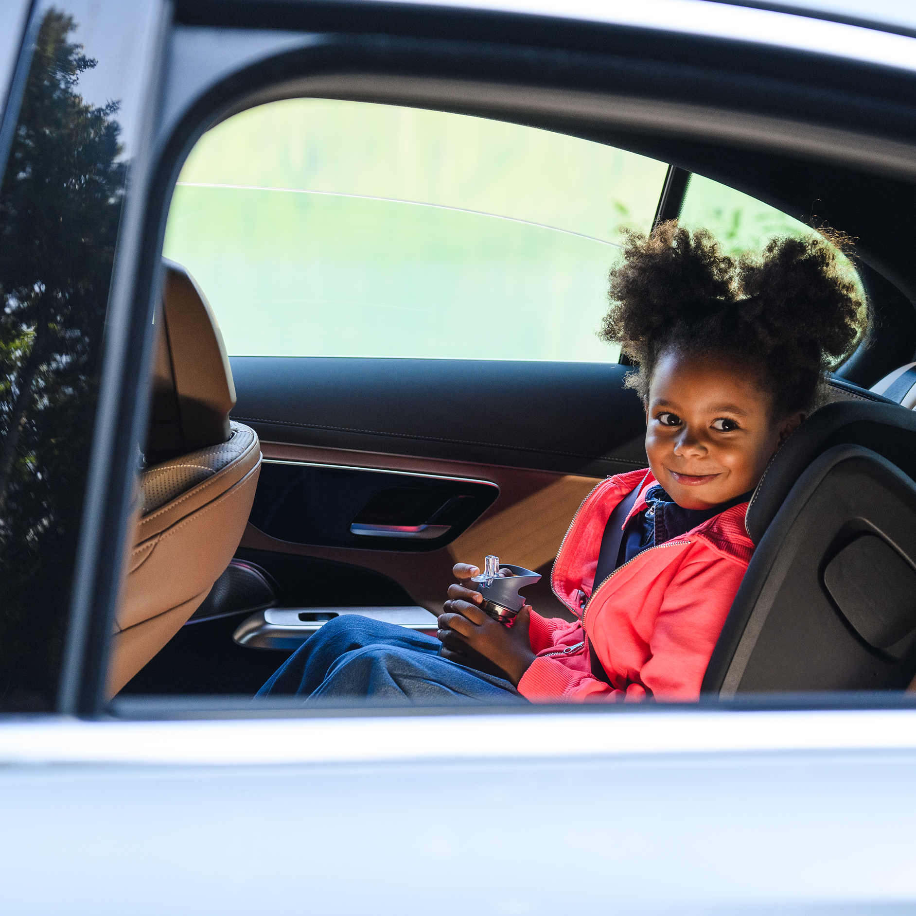 Seguros | Servicios financieros | Mercedes-Benz Una niña sentada dentro de un vehículo Mercedes-Benz.