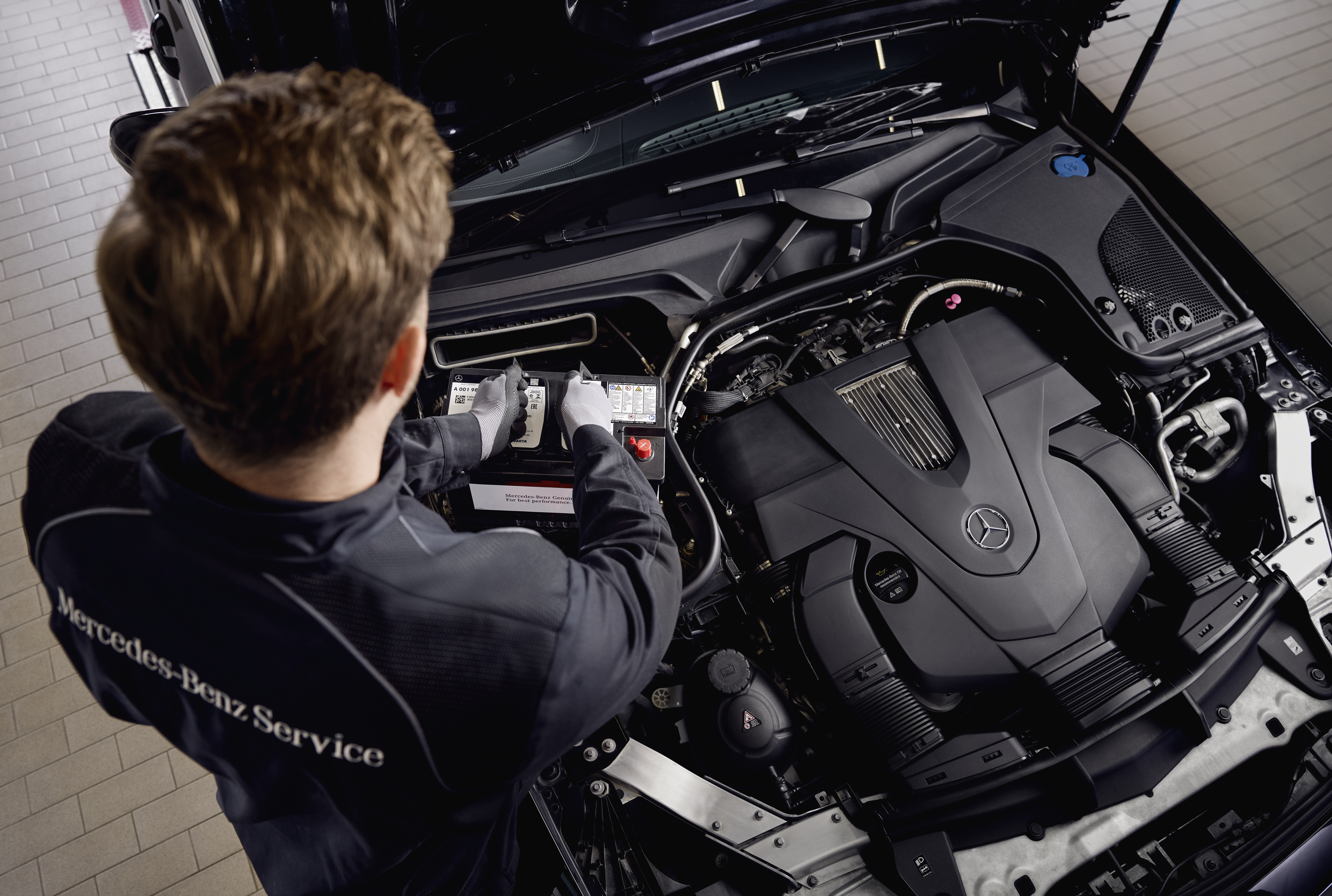 Baterías de arranque originales Mercedes-Benz Revisión del motor en un taller, mostrando la sustitución de componentes con piezas originales Mercedes-Benz.