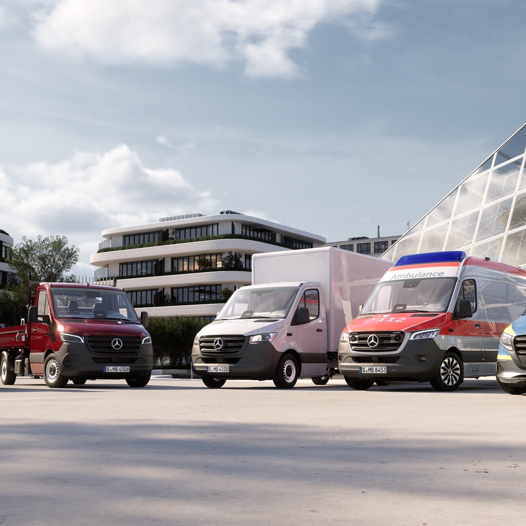 Diversas furgonetas Mercedes-Benz con soluciones individuales de carrocerías y modificaciones están aparcadas una al lado de la otra en una zona abierta frente a una arquitectura moderna, incluyendo vehículos para logística, construcción, gremios y uso comercial.