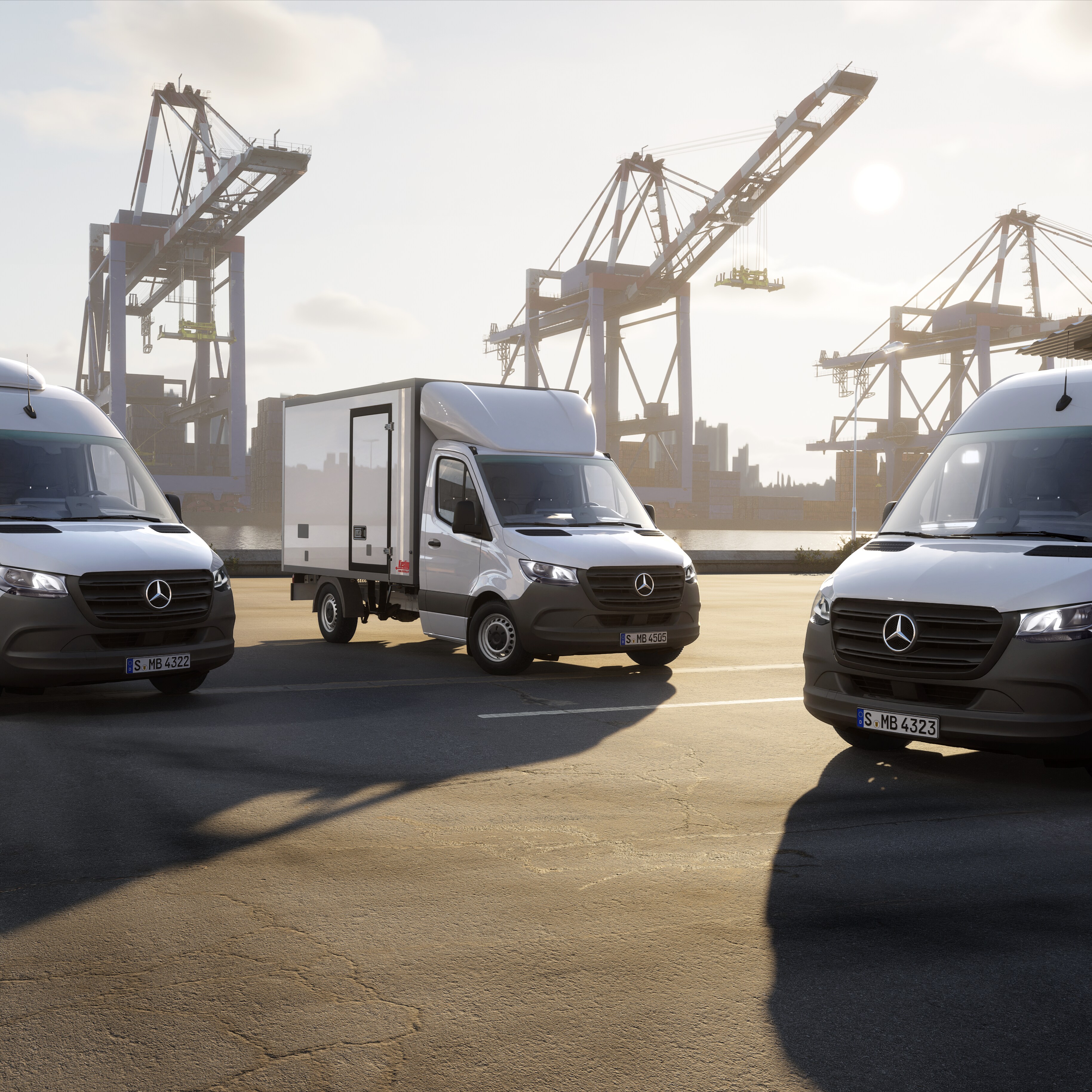 Tres furgonetas Mercedes-Benz situadas en una terminal de contenedores con grúas portuarias: soluciones de vehículos eficientes para servicios de mensajería, exprés y logística.