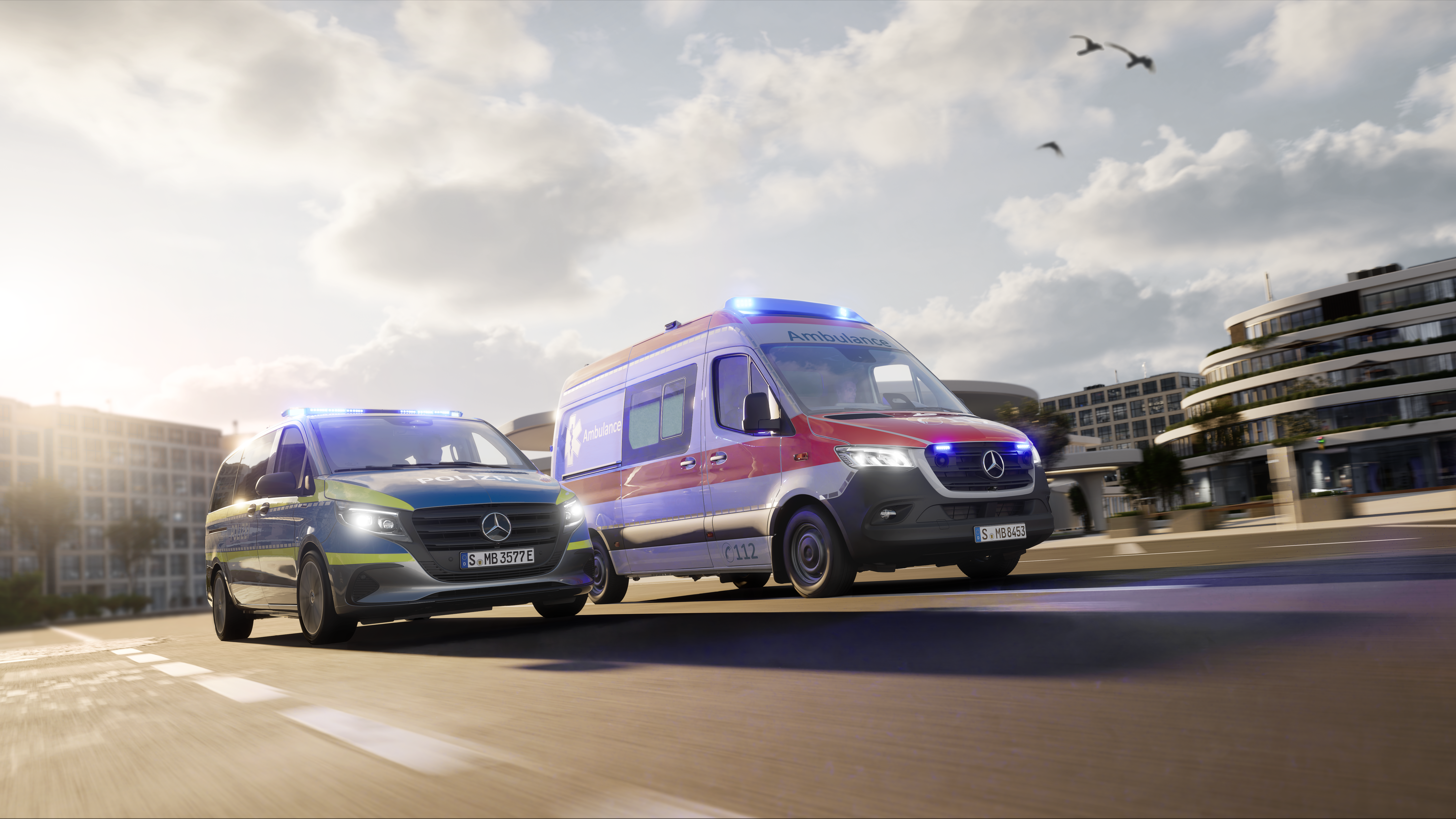 Ambulancia Mercedes-Benz basada en la Sprinter y furgoneta de operaciones en uso de emergencia. Dos vehículos especiales de Mercedes-Benz, una ambulancia basada en la Sprinter y un vehículo policial con luces azules activadas, circulan por un entorno urbano: soluciones fiables en vehículos para operaciones de rescate y emergencia.