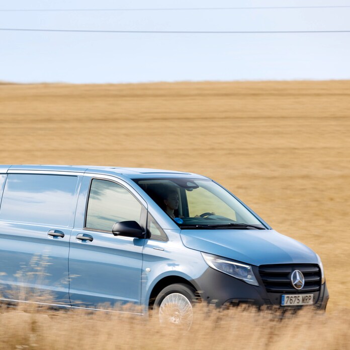 Mercedes-Benz Vito azul circulando por carretera rural entre campos abiertos.