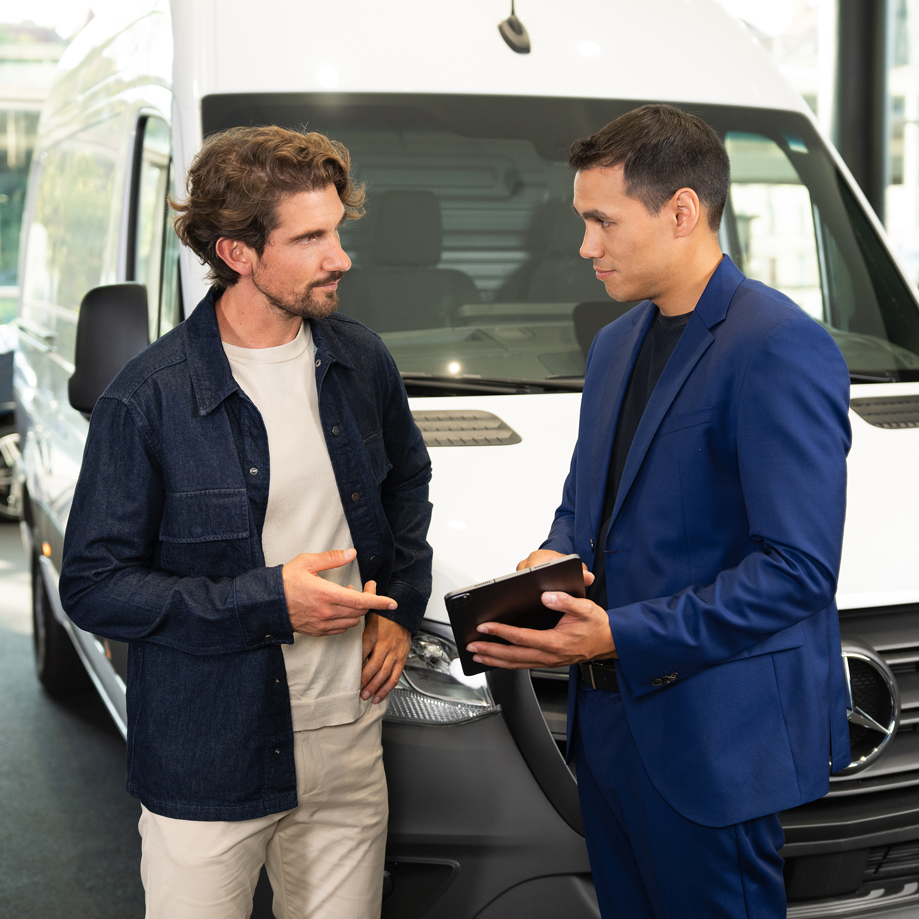 Vehículos usados |Financiación y precios | Servicios financieros | Mercedes-Benz Dos hombres conversan frente a una furgoneta Mercedes-Benz.