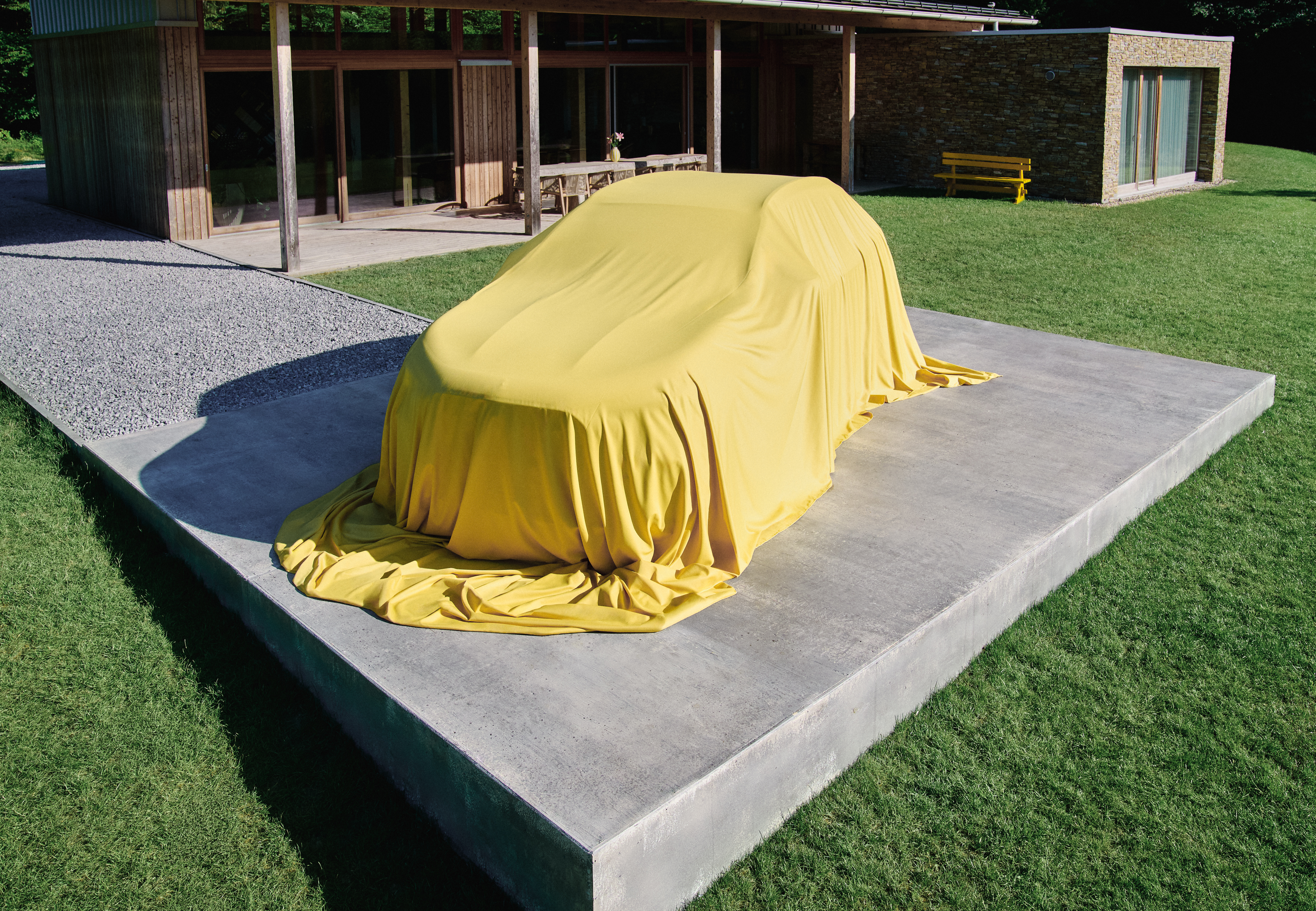 Nuevo GLA | Mercedes-Benz Vista del nuevo GLA aparcado fuere de una casa bajo un velo amarillo
