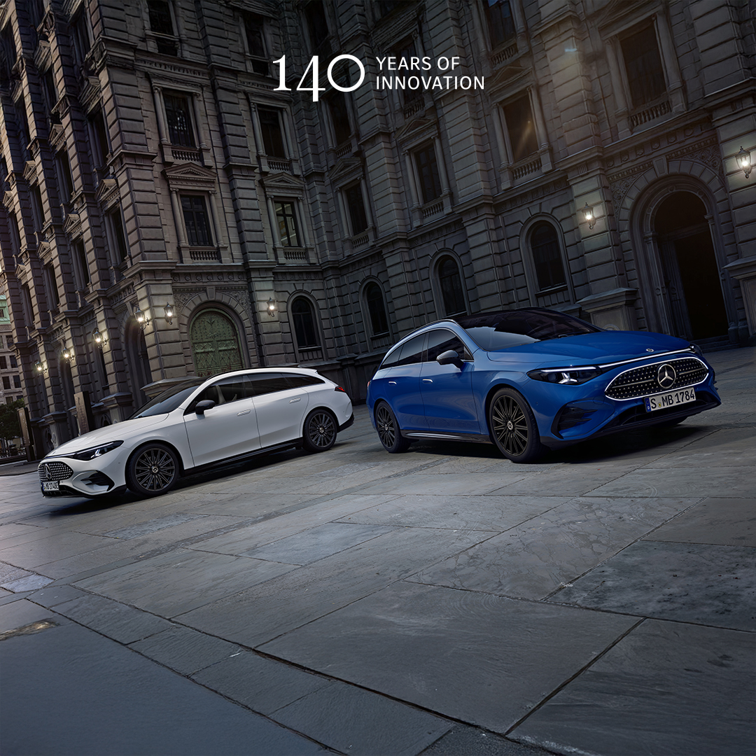 Visual lateral frontal del CLA Shooting Brake eléctrico en color blanco y el CLA Shooting Brake híbrido en color azul aparcados frente de un edificio